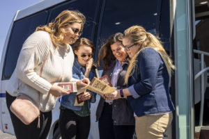 4 women lookign at a pour tour brochure