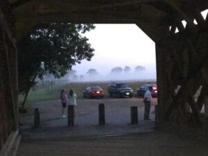group gathering next to a covered bridge for a ghost bus tour